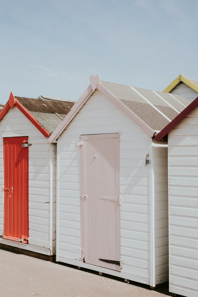 pastel beach huts by beach scaled