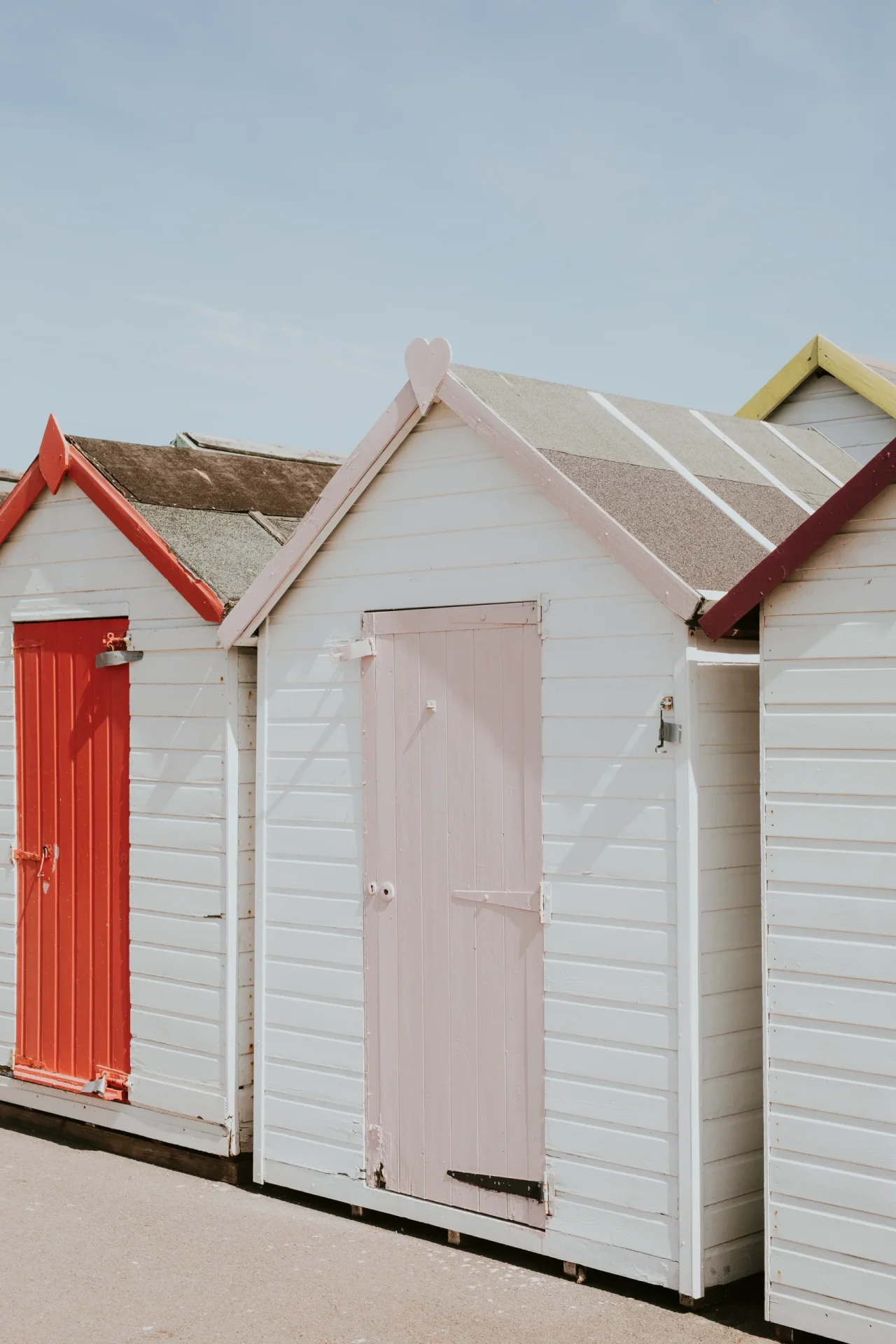 pastel beach huts by beach scaled
