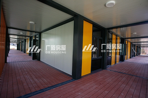 covered outdoor corridor of modular container building with orange doors covered outdoor corridor of modular container building with orange doors