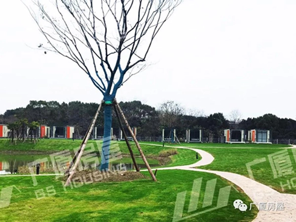 modular hotel buildings connected by landscaped walkways and trees