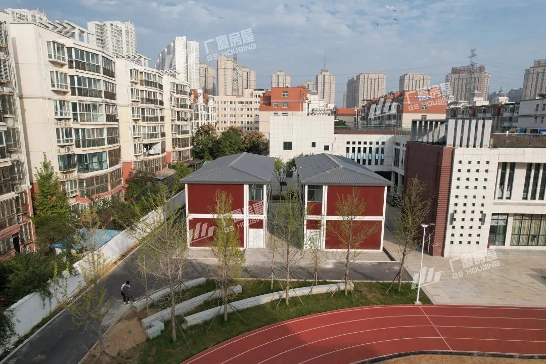 modular school campus building aerial view with red facade classroom blocks and residential buildings background modular school campus building aerial view with red facade classroom blocks and residential buildings background