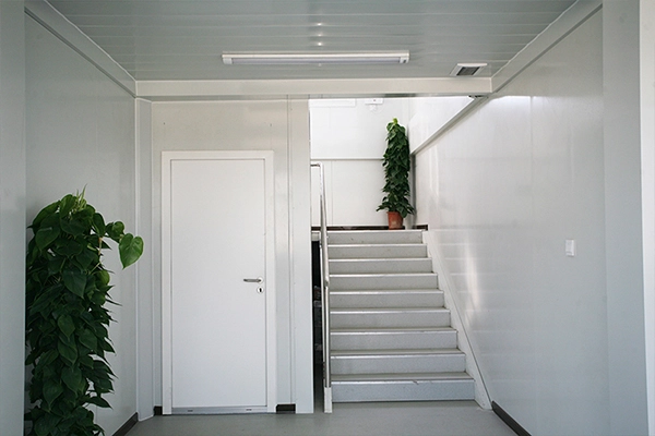 prefab container building staircase with white walls and indoor plants prefab container building staircase with white walls and indoor plants