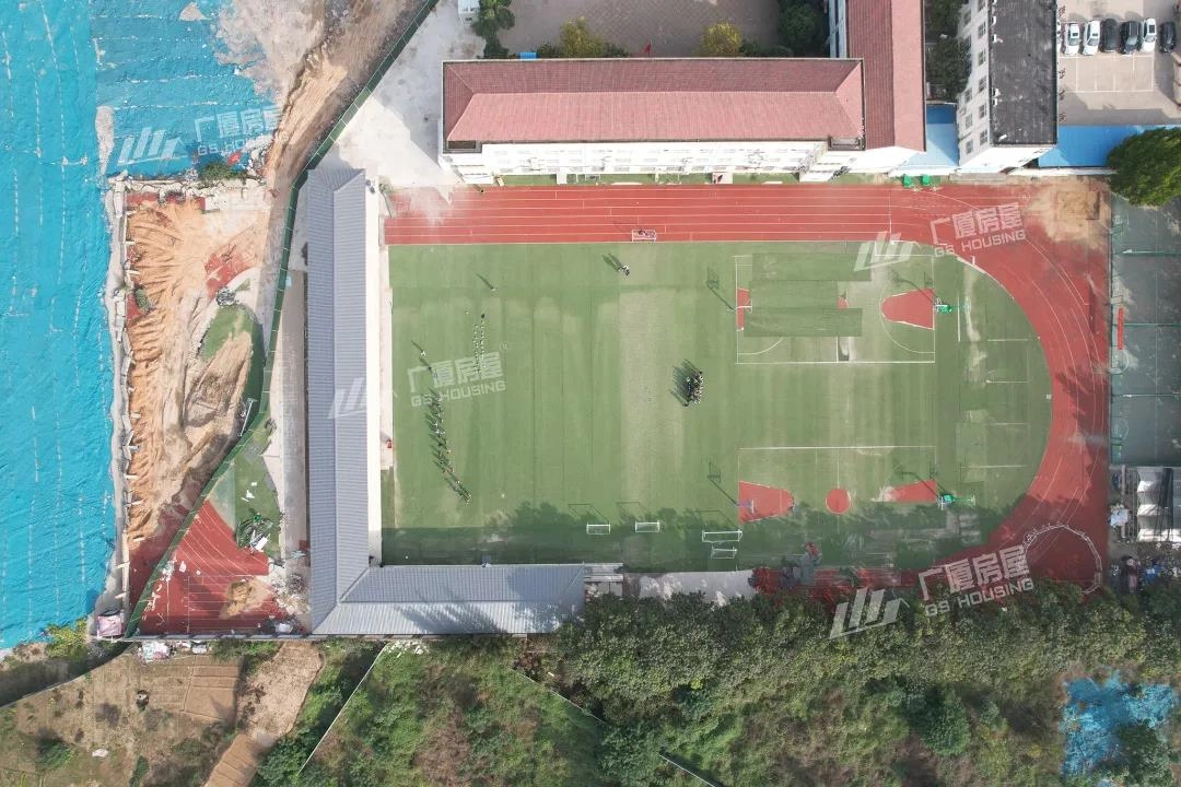 primary school campus aerial view with sports field and surrounding classroom buildings