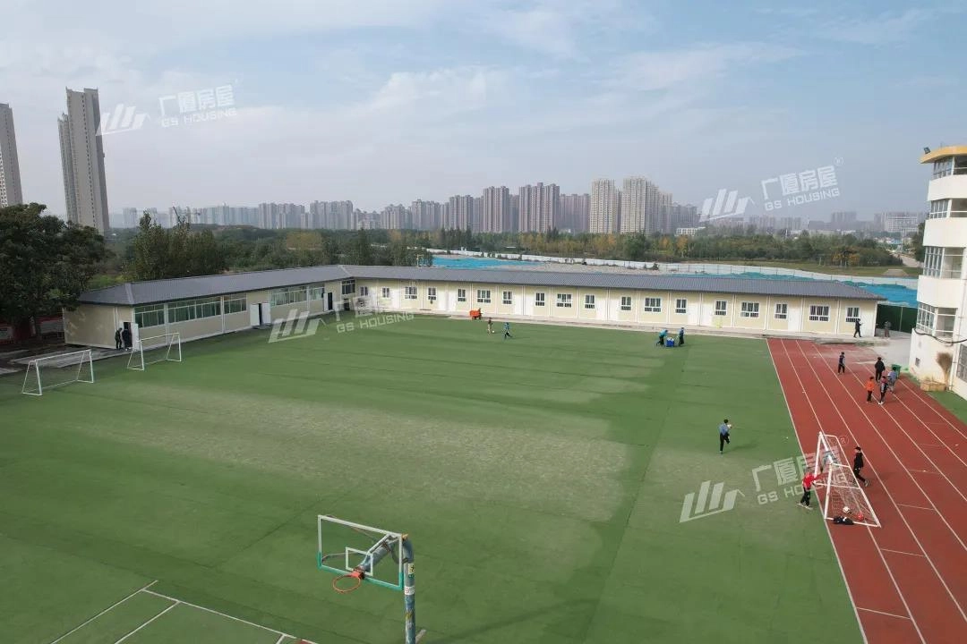 school sports ground with modular teaching buildings arranged around campus area