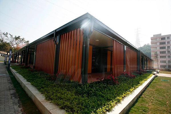 single-story prefab office building with wood color facade and garden walkway single-story prefab office building with wood color facade and garden walkway