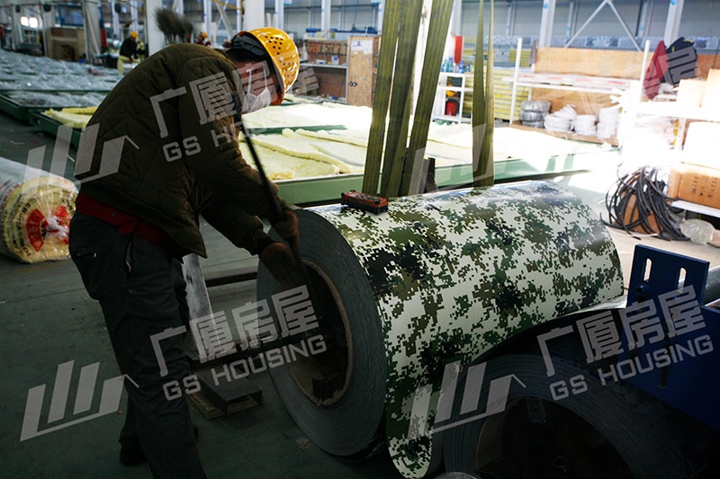 worker assembling camouflage wall panel for military camp container house worker assembling camouflage wall panel for military camp container house