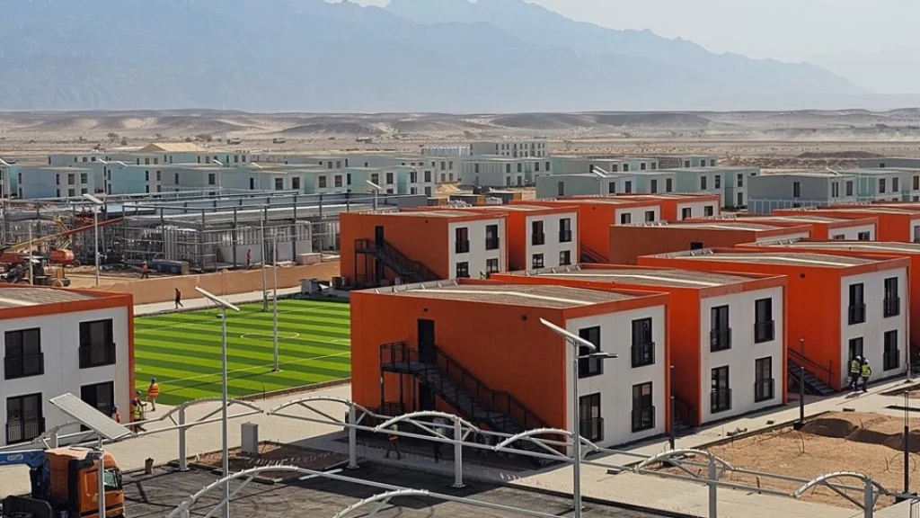 labor camp worker housing area with modular buildings and mountain background