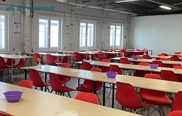 modular camp dining hall interior with red chairs and worker canteen layout