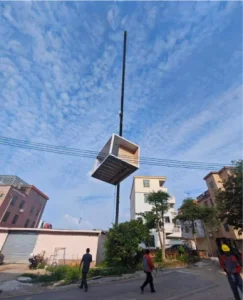 Crane lifting a modular toilet unit into foundation position at Sucun project site