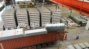 Flat-pack wall panels being loaded for transport at the factory