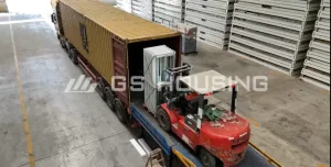 Packed flat-pack modular building components prepared for container shipping