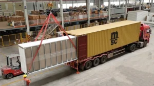 Prefabricated modular building unit being loaded onto a container truck for project delivery