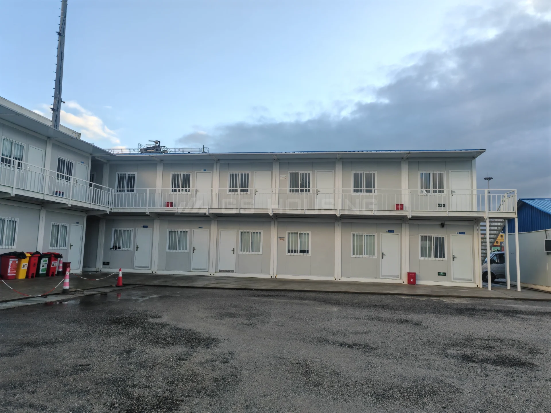 Two-storey modular site building at the Guinea Conakry Port Expansion Phase II project, with external access corridors, individual rooms and a paved working area